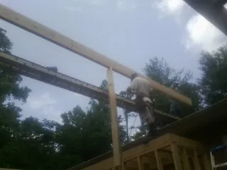 Carpenter setting a ridge beam over a new addition frame — Ice Dam Removal by Roofing Brothers in Westlake Village