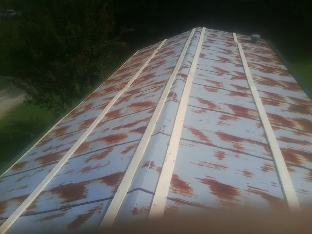 Rusted metal roof panels with new wood purlins before replacement — Storm Damage Roof Repair in Westlake Village by Roofing Brothers