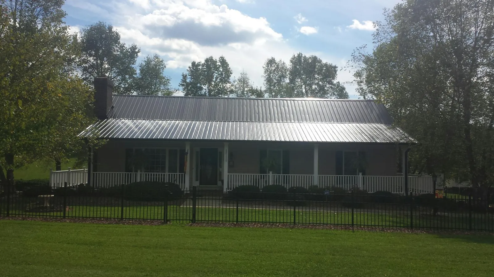 Gray metal roof on a brick ranch with a full width front porch — Gutter Guard Installation work by our crew in Westlake Village