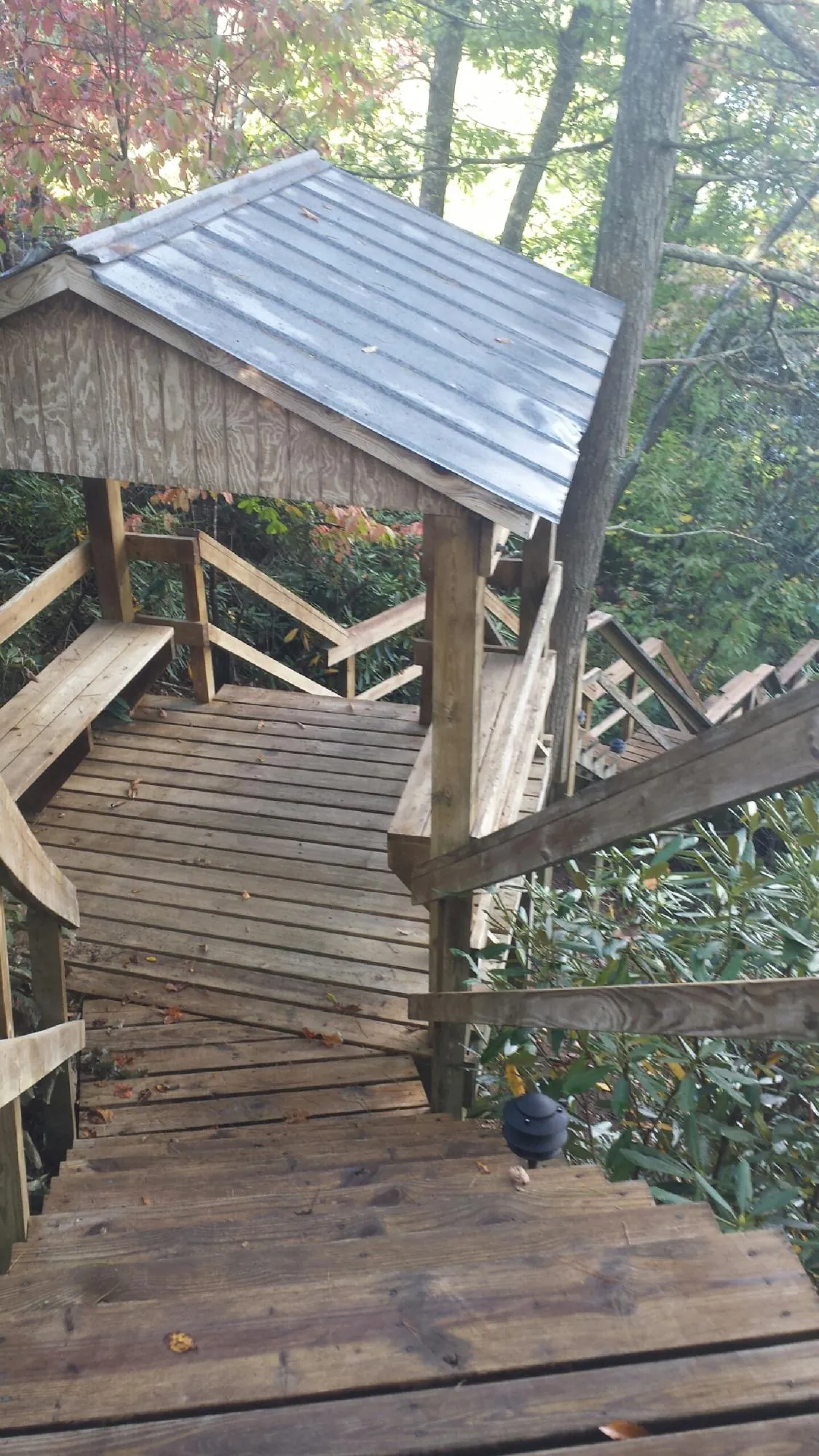 Metal roofed shelter over wooden steps on a wooded walkway — Skylight Repair & Installation work by our crew in Westlake Village